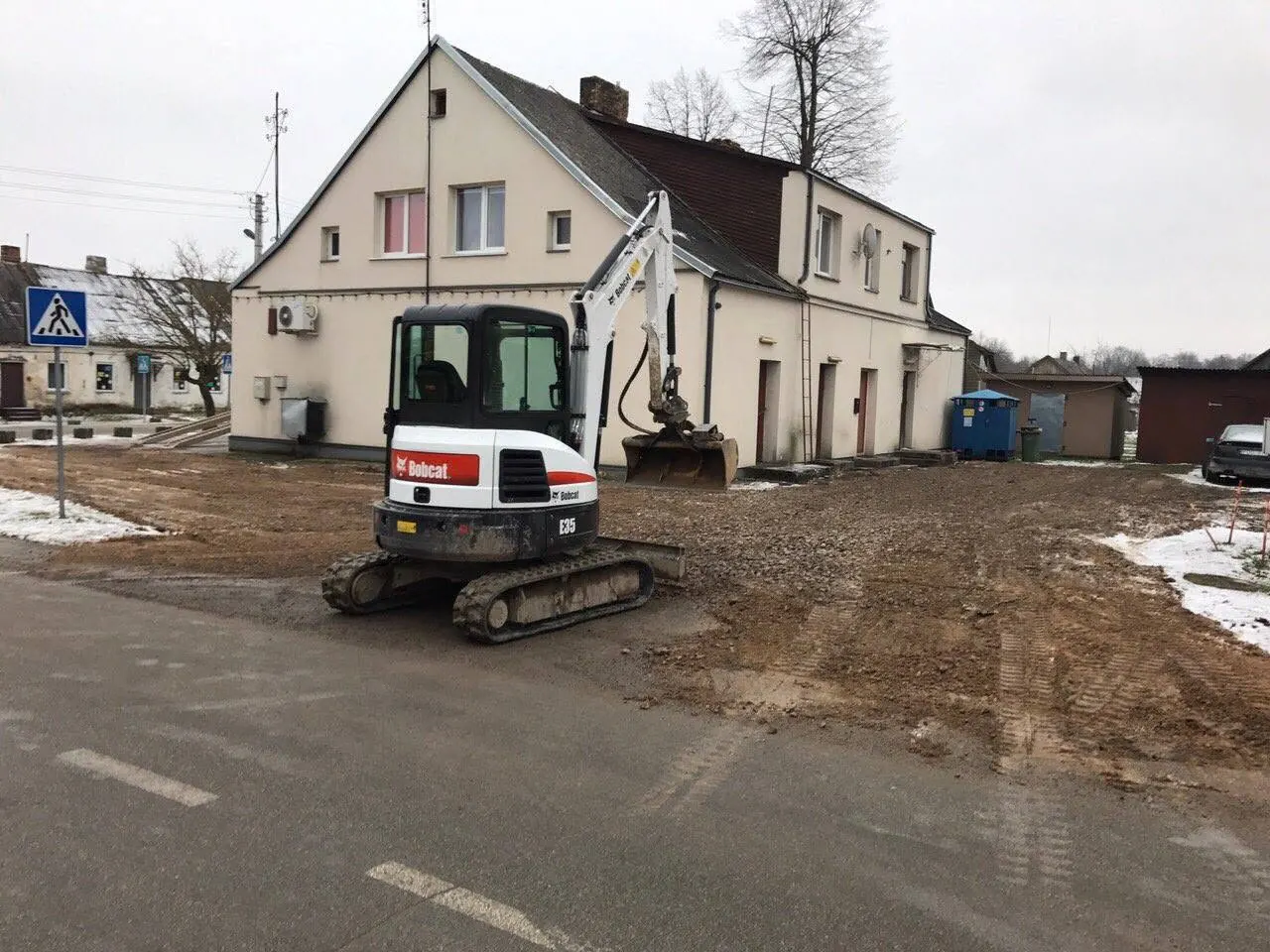 Ekskavatorius dirba gyvenamojo namo statybvietėje